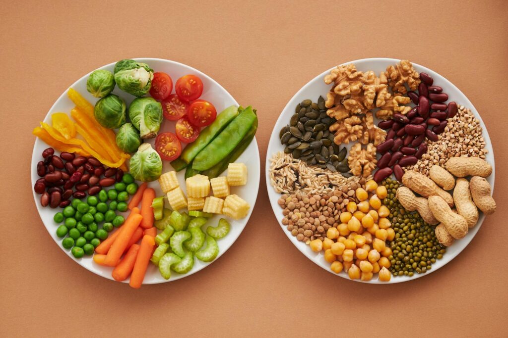 2 plates of Assorted Vegetables Beside a Plate of Nuts and Beans