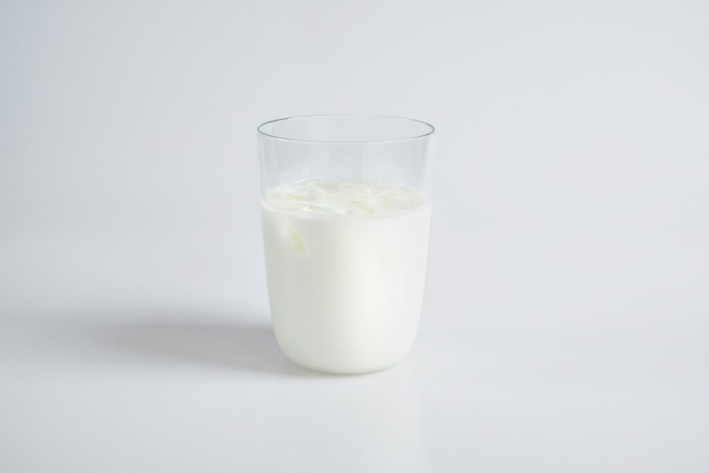 white liquid of fresh cow's milk in clear drinking glass