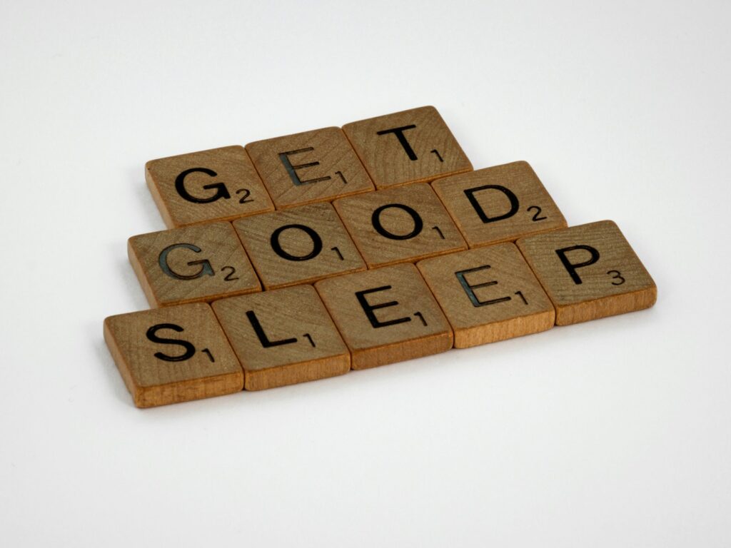brown wooden letter blocks from the scrabble board game on white surface that says 'get good sleep'