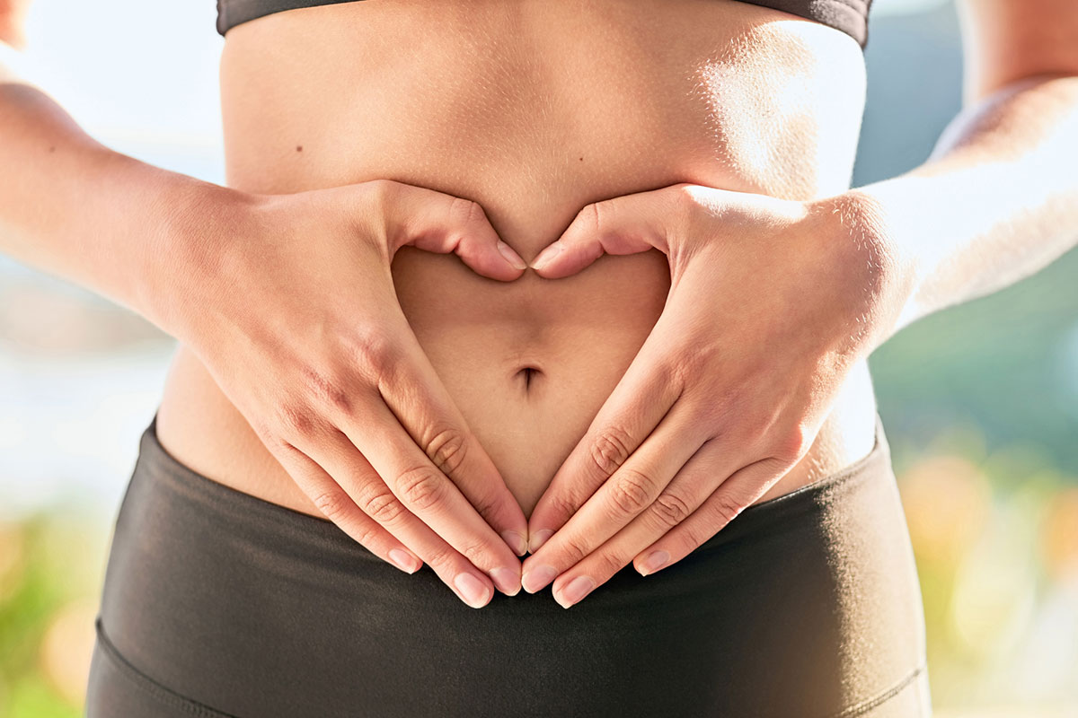 woman making a heart on her belly with her hands after taking Korbiotic from Genesis Supplements