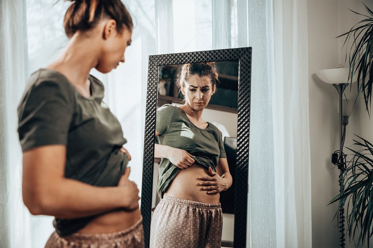 woman looking in mirror considering taking Korbiotic from Genesis Supplements