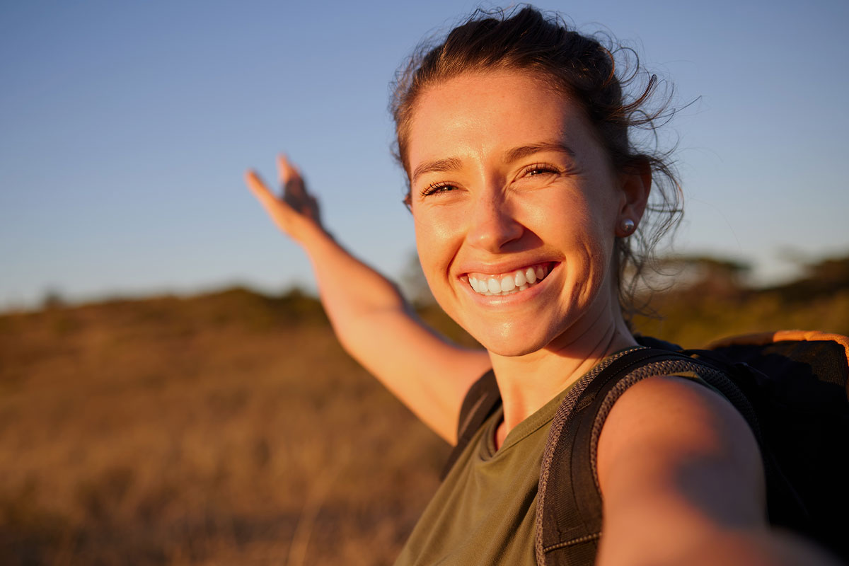 woman smiling outside after taking a quality probiotic, called Korbiotic