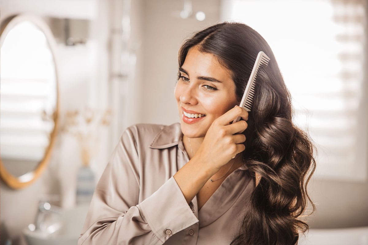 woman brushing her hair after her Korbiotic probiotic helped her hair growth